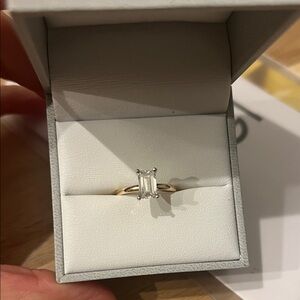1.30 carat lab diamond emerald cut solitaire set in white gold on a yellow gold